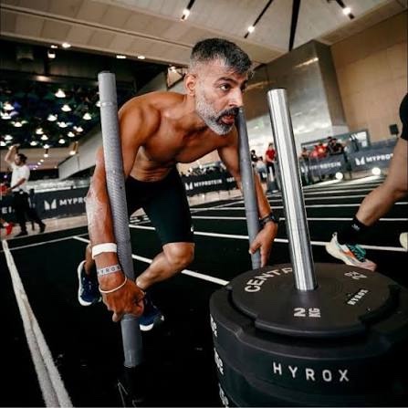 Amarjit Singh pushing a weighted sled at a HYROX competition